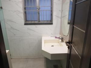 a bathroom with a white sink and a window at Tulip Dream Suite in DHA Phase-6 Lahore in Lahore