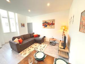 a living room with a couch and a table at L'Ibéris - Toutes les commodités dans la rue - 1er étage in Auch +2 photos
