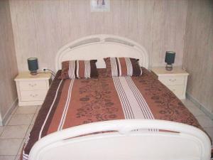 a bedroom with a large bed with two night stands at Appartement charmant à Breuillet avec jardin spacieux in Breuillet