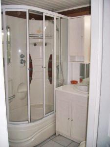 a white bathroom with a shower and a sink at Appartement charmant à Breuillet avec jardin spacieux in Breuillet