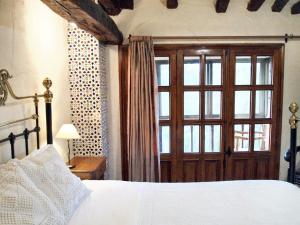 a bedroom with a bed and a large window at Charming House in Villasur de Herreros with Lake View in Villasur de Herreros +18 photos