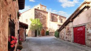an alley with a building with a clock tower at Charming House in Villasur de Herreros with Lake View in Villasur de Herreros