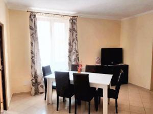 a dining room with a table and chairs and a window at Charming House in Săcele with Garden View + BBQ in Săcele