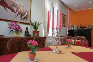 a dining room table with a candle and flowers on it at Hotel Domodossola in Domodossola