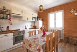a kitchen with a table with a vase of flowers on it at Appartement spacieux à Briançon 86 m² avec vue montagne in Briançon