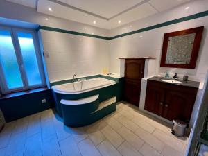 a large bathroom with a tub and a sink at Les Romarins in Vallières-les-Grandes +38 photos