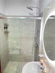 a bathroom with a shower and a sink and a mirror at Dora apartment in Tirana +6 photos