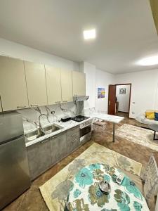 a kitchen with a sink and a refrigerator and a table at Dora apartment in Tirana
