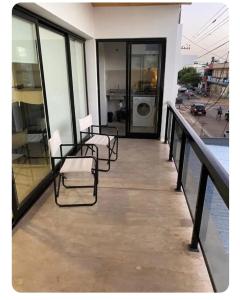 ベジャ・ビスタにあるSiloé Bella Vistaの建物の上の椅子と洗濯機のあるバルコニー