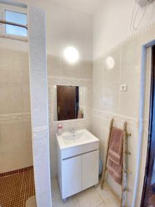 a white bathroom with a sink and a mirror at Charming House in Barão de São Miguel in Barão de São Miguel +15 photos