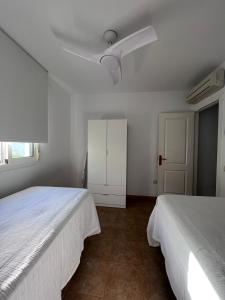 Un dormitorio con dos camas y un ventilador de techo. en Casa Turquesa, en San José 6 fotos más