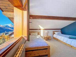 a bedroom with two beds and a large window at Appartement cosy avec mezzanine et balcon, au pied des pistes, Wi-Fi inclus - FR-1-344-825 in Saint-Martin-de-Belleville
