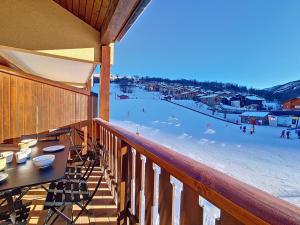 a balcony with a table and a beach with people on it at Appartement cosy avec mezzanine et balcon, au pied des pistes, Wi-Fi inclus - FR-1-344-825 in Saint-Martin-de-Belleville +10 photos