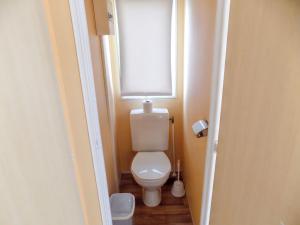 a bathroom with a toilet with a window above it at Charming Bungalow in Pataias with Shared Pool in Pataias