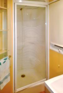 a shower with a glass door in a bathroom at Comfortable Bungalow Near Pataias with Shared Pool in Pataias