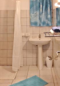 a white bathroom with a sink and a shower at Appartement accueillant à Sainte-Anne – 60 m² avec piscine in Sainte-Anne