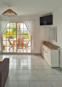 a living room with a view of a patio at Appartement accueillant à Sainte-Anne – 60 m² avec piscine in Sainte-Anne