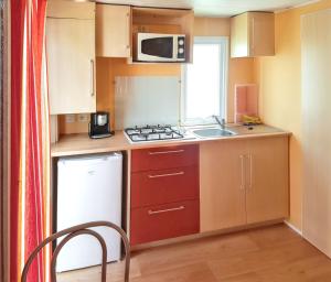a small kitchen with a sink and a microwave at Charming Bungalow in Pataias, 18 m² with Shared Pool. in Pataias