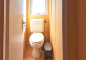 a bathroom with a toilet and a window at Charming Bungalow in Pataias, 18 m² with Shared Pool. in Pataias