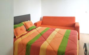 a bedroom with a bed with an orange and green quilt at Charming Bungalow in Pataias with Shared Pool in Pataias