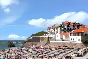 a beach with a lot of umbrellas and the ocean at Charming Bungalow in Pataias, 18 m² with Shared Pool. in Pataias +13 photos