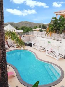 a swimming pool in a resort with a table and chairs at Appartement accueillant à Sainte-Anne – 60 m² avec piscine in Sainte-Anne