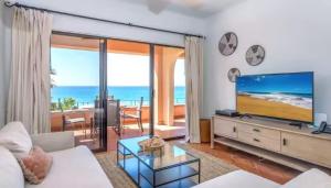 a living room with a large television and the ocean at 2BD Exclusive Cabo Corridor Beach Front Luxury in San José del Cabo