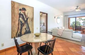 a living room with a table and chairs and a painting at 2BD Exclusive Cabo Corridor Beach Front Luxury in San José del Cabo