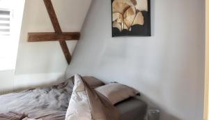 エギスハイムにあるAppartement cosy avec cheminée à Eguisheim - 110m² - Terrasseの壁に十字架が付いた部屋のベッド1台