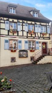 エギスハイムにあるAppartement cosy avec cheminée à Eguisheim - 110m² - Terrasseの青いシャッターと花の建物