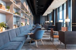 a waiting room with blue couches and tables at Clarion Hotel Air in Sola
