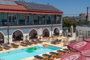 an outdoor swimming pool with chairs and a building at HOTEL KM 0 in Costinesti