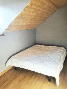 un letto in una stanza con soffitto in legno di Maison de charme à Gan avec vue sur la montagne a Gan