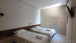 a small room with two beds and a television at Casa mobiliada de 2 quartos na R Oliveira Alves Fontes, 609 E 603 - Jardim Gonzaga in Juazeiro do Norte