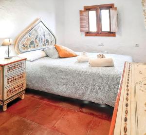 a bedroom with a bed and a dresser with towels on it at Spacious House with Private Pool El Soto in El Cañal