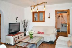 a living room with a white couch and a tv at Spacious House with Private Pool El Soto in El Cañal