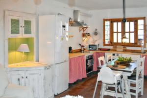 a kitchen with a white refrigerator and a table at Spacious House with Private Pool El Soto in El Cañal