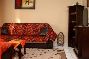 ein Wohnzimmer mit einem roten Sofa und einem Tisch in der Unterkunft VILA SOFi in Néa Karyá