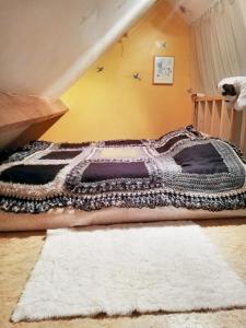 a bedroom with a large bed with a white rug at Cozy Apartment in Estinnes – 40 sqm with a fenced garden. in Estinnes-au-Val