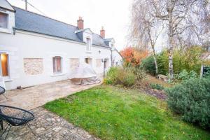 a white house with a yard with chairs at Les Romarins in Vallières-les-Grandes