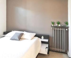 sypialnia z białym łóżkiem i grzejnikiem w obiekcie Maison charmante à Monteux avec jardin et équipements complets w mieście Monteux