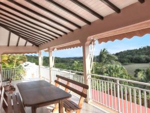 サンタンヌにあるVilla de charme à Sainte-Anne avec piscine privéeの海の景色を望むバルコニー(テーブル付)