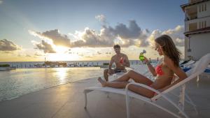 a man and a woman sitting in lawn chairs on the beach at Grand Park Royal Cancun in Cancún
