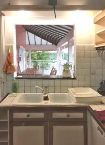 サンタンヌにあるVilla de charme à Sainte-Anne avec piscine privéeのキッチン(シンク、鏡付)