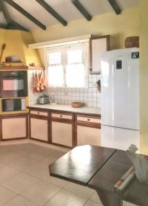 サンタンヌにあるVilla de charme à Sainte-Anne avec piscine privéeのキッチン(白い冷蔵庫付)、窓