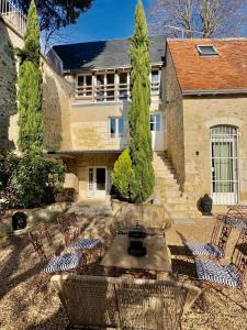 einen Außenblick auf ein Haus mit Stühlen und Bäumen in der Unterkunft L'Olivier - Charm and elegance Loire Valley in Vouvray