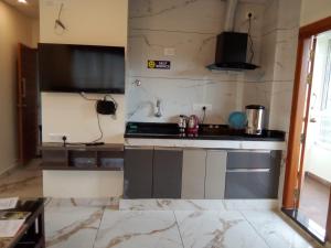 a kitchen with a sink and a stove at Kamadhenu Residency Homestay & Service Apartment Coorg Madikeri in Madikeri