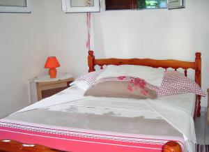 a bed with a wooden headboard in a bedroom at Maison charmante Deshaie + Vue in Deshaies