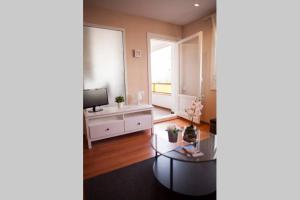 a living room with a table and a television at Apartamento Alameda in Valencia