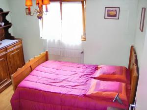 a pink bed in a room with a window at Appartement charmant à Jebsheim avec terrasse et jardin in Jebsheim